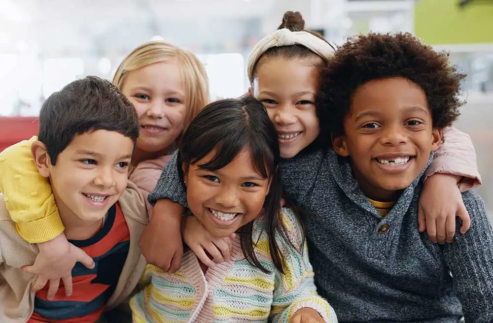 A group of young kids smiling at daycare.